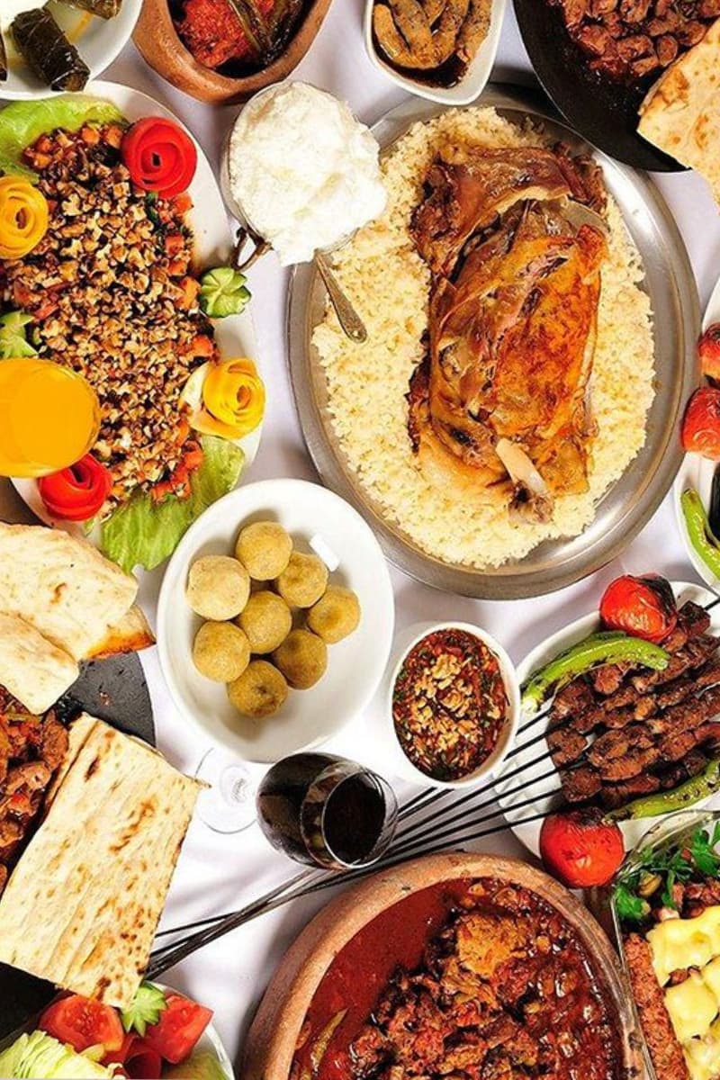 Seekh kebabs, karahi, and rice dishes on a wooden table
